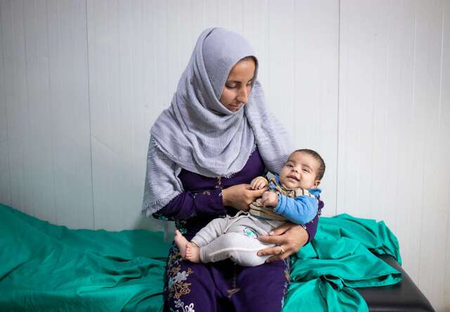 아기를 품에 안고 있는 한 시리아 난민 엄마